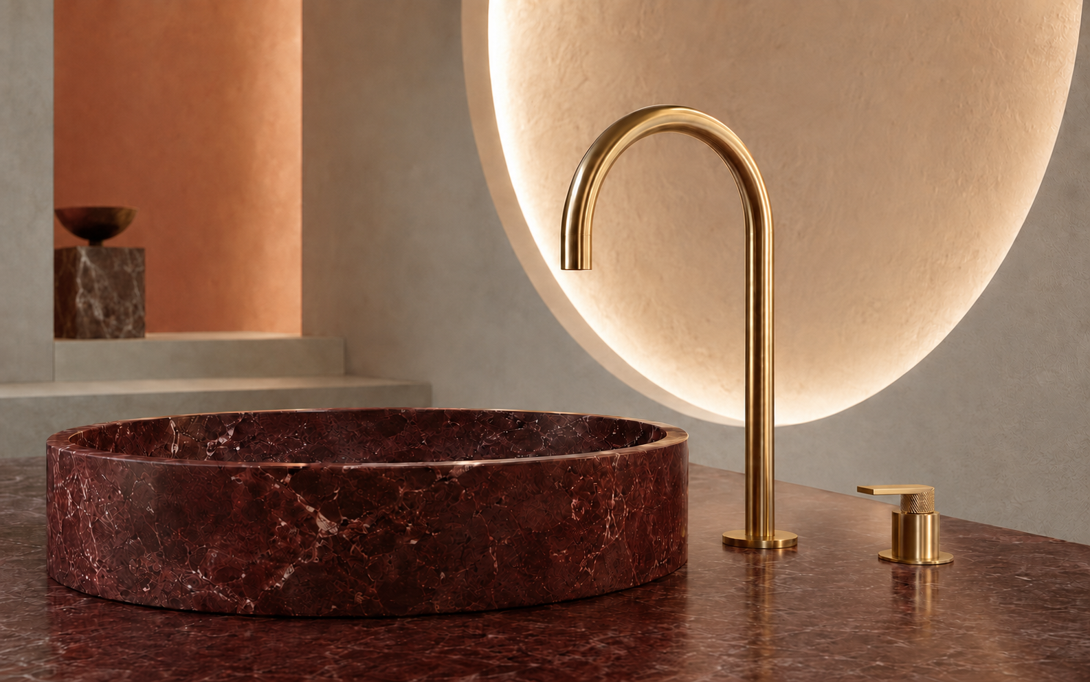 Sculptural brass faucet above a burgundy stone basin